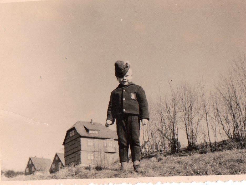 Frank, im Alter von 4 Jahren, im Hintergrund das Haus seiner Großeltern